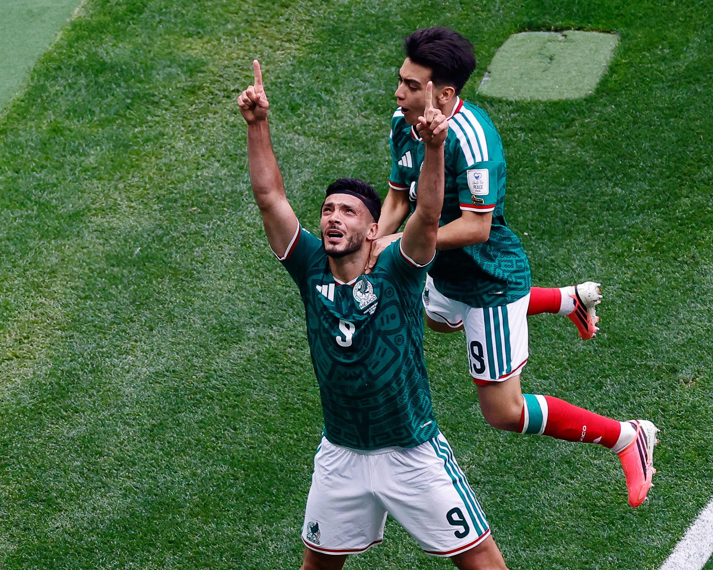 Raúl Jiménez points up to the sky after he scores