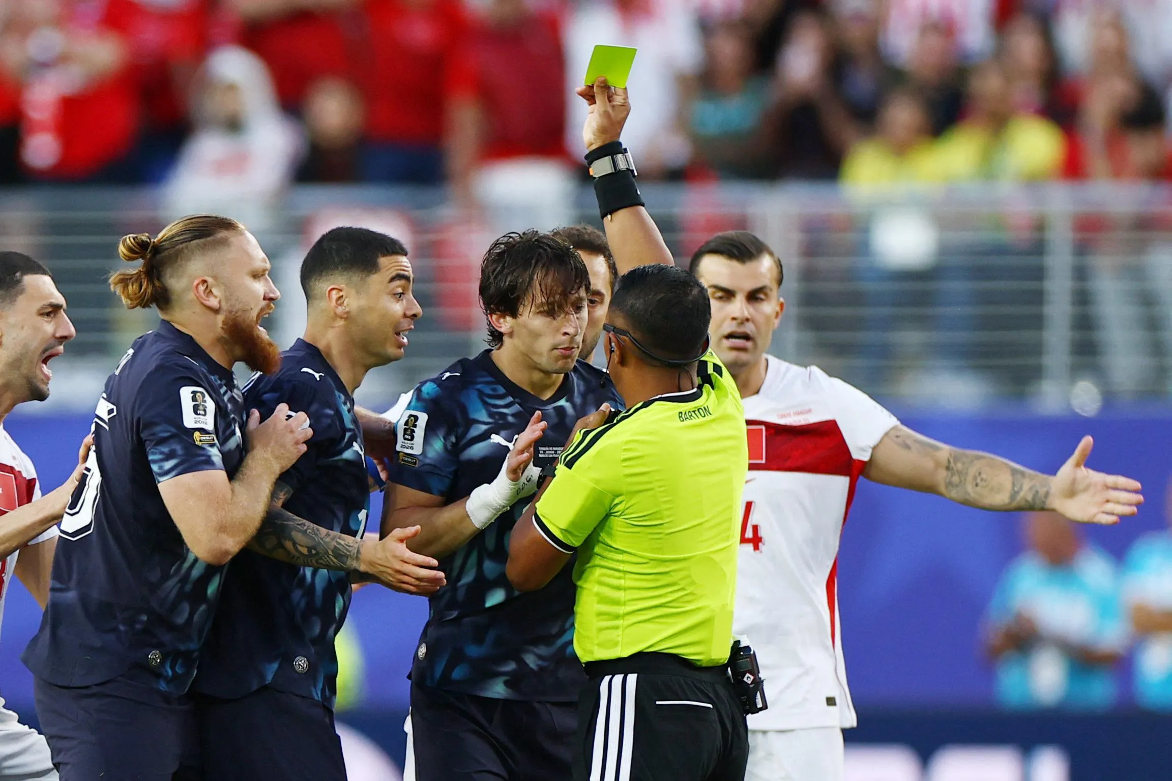 Paraguay's Matias Galarza is shown a yellow card by referee Ivan Barton.