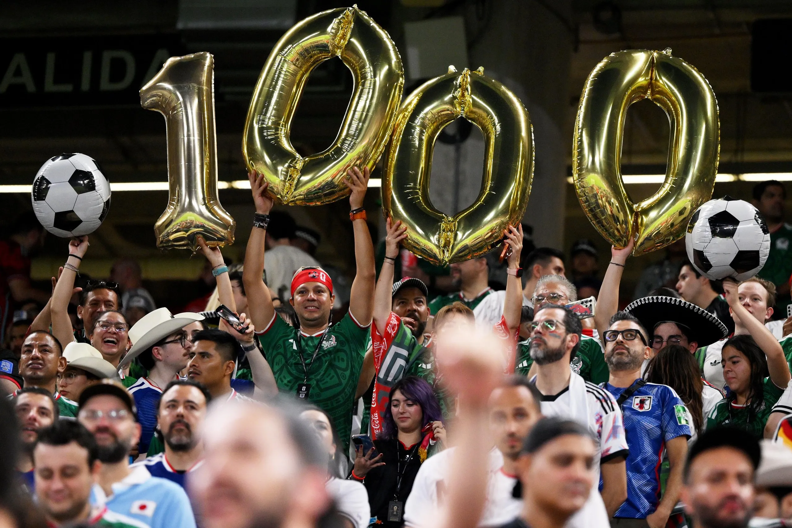 Fans hold up balloons celebrating the 1000th match.