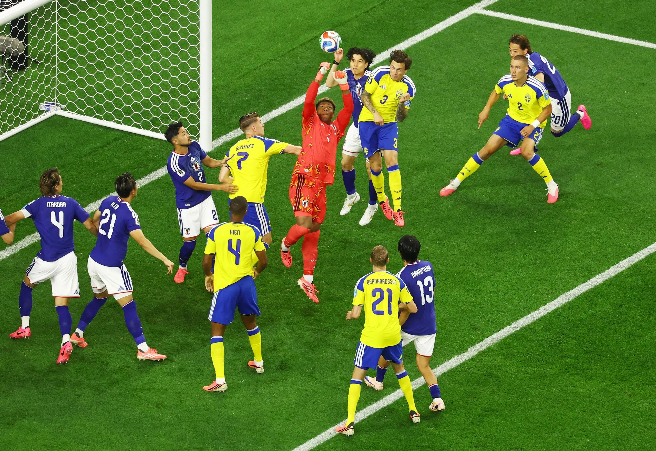 Zion Suzuki and Ao Tanaka in action with Sweden's Victor Lindelof.
