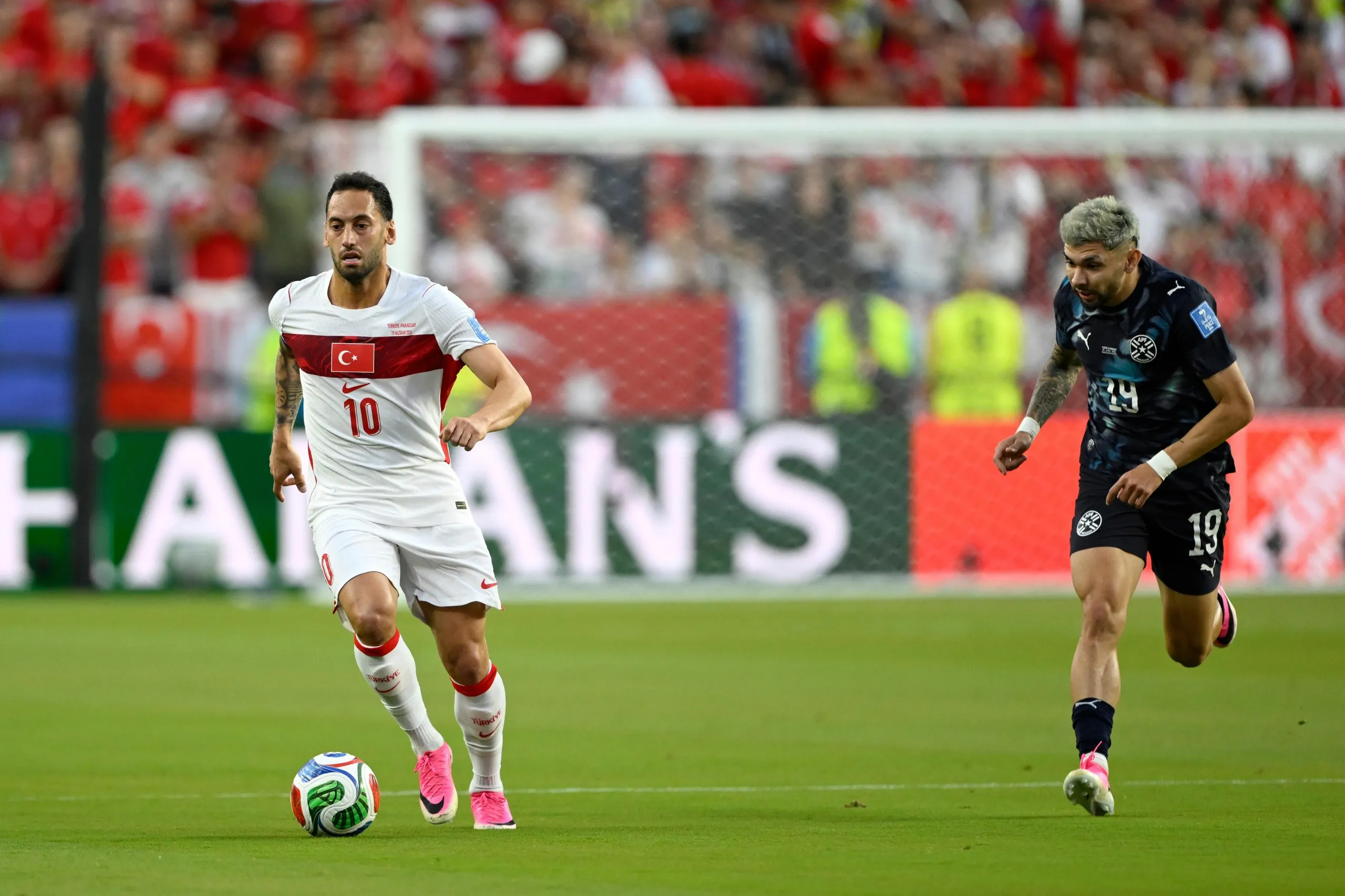 Turkey's Hakan Calhanoglu (10) controls the ball against Paraguay's Julio Enciso (19).