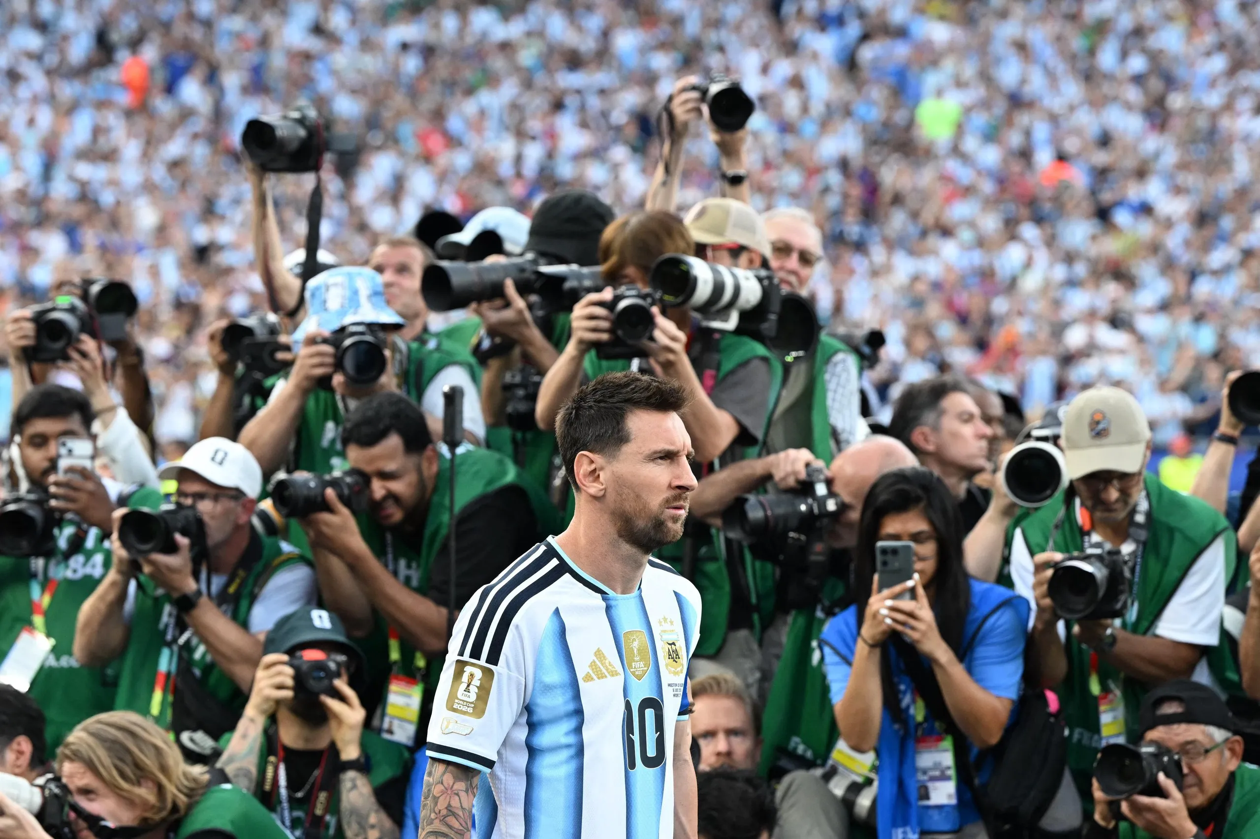 A mass of photographers snap away as Lionel Messi enters the pitch before Argentina’s game against Algeria