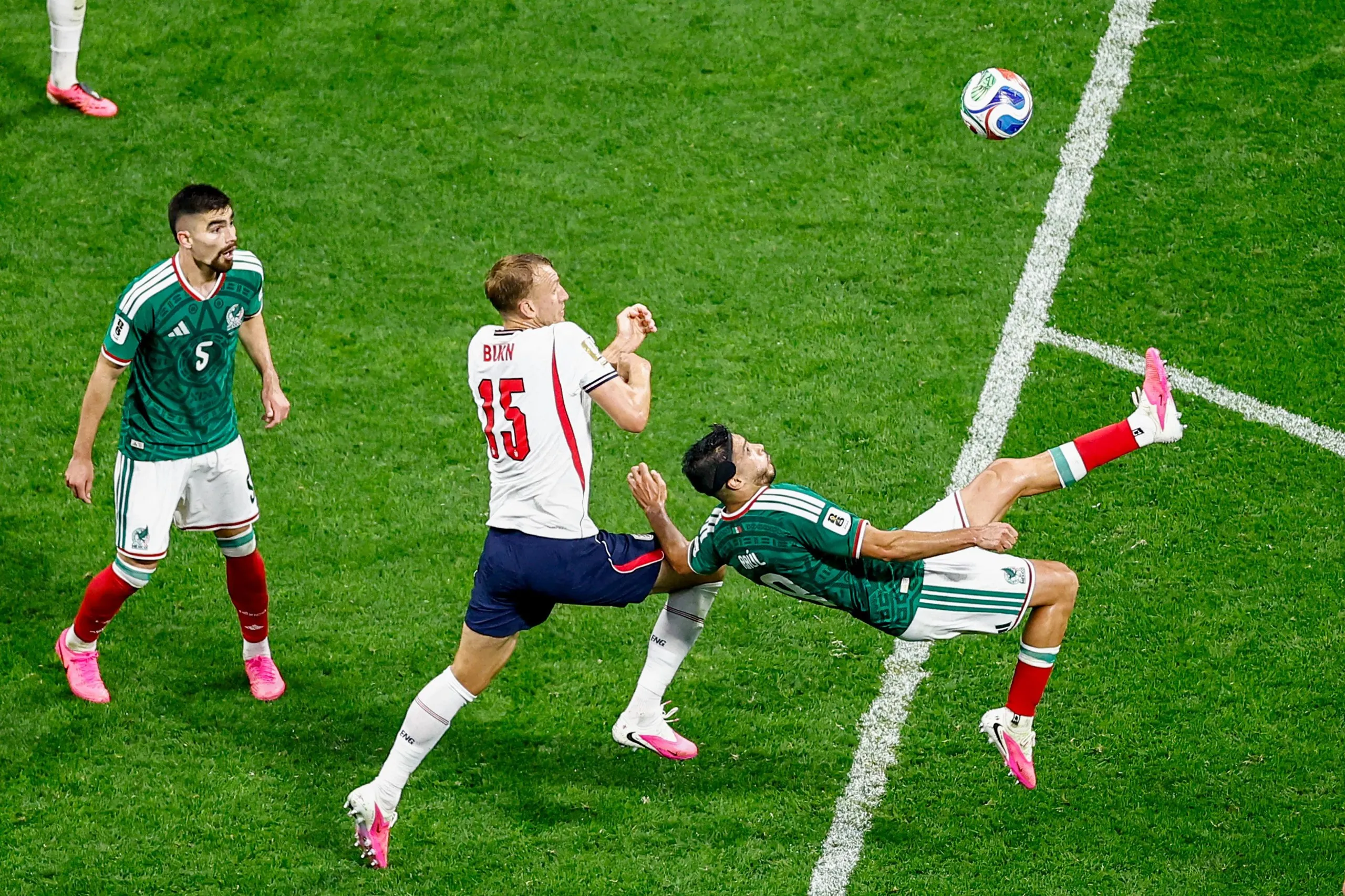 Mexico's forward Raúl Jiménez makes a bicycle kick as Dan Burn closes in
