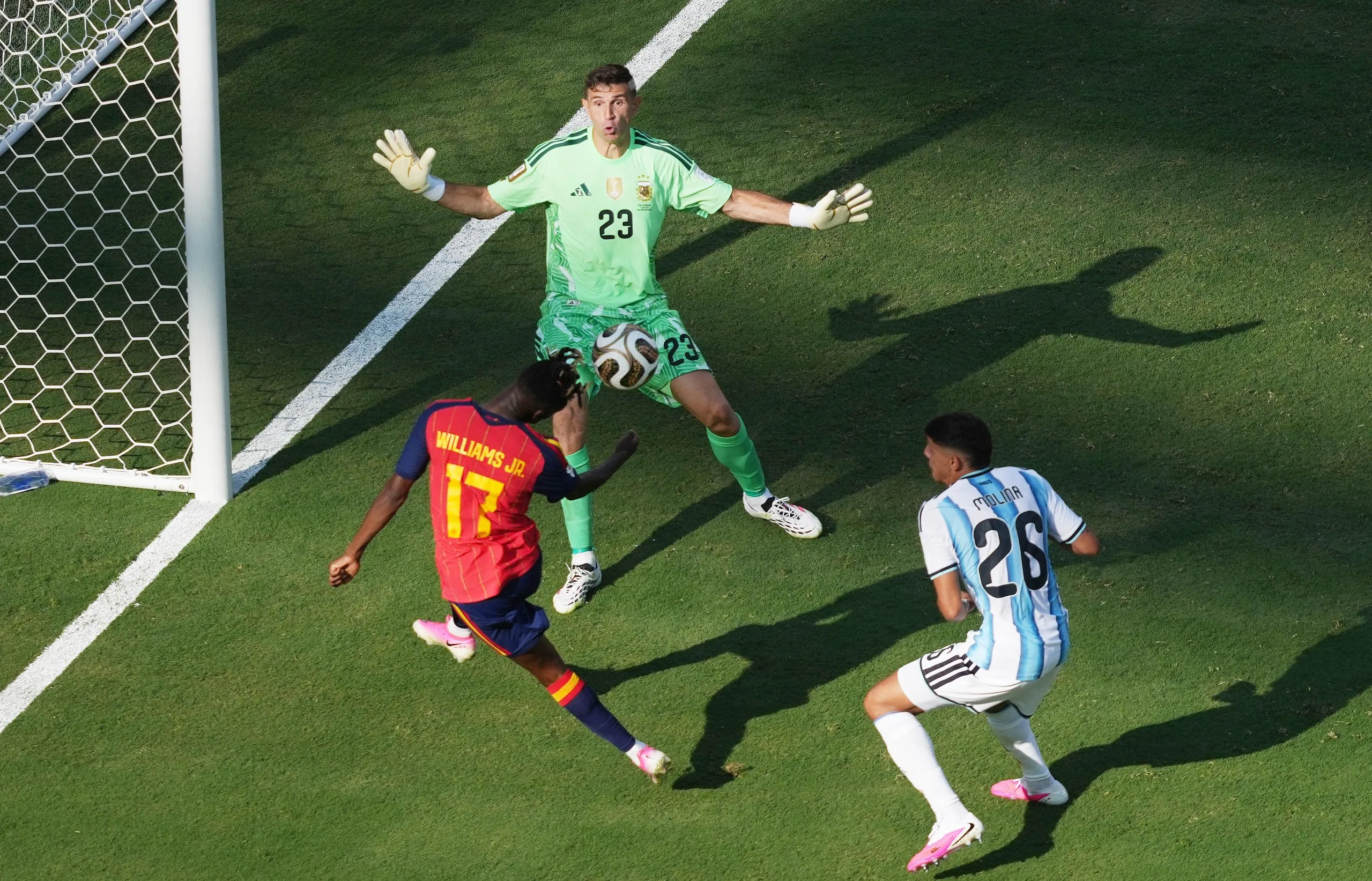 Spain’s Nico Williams heads the ball back from Argentina’s Emiliano Martinez and Nahuel Molina for teammate Ferran Torres to score their first goal