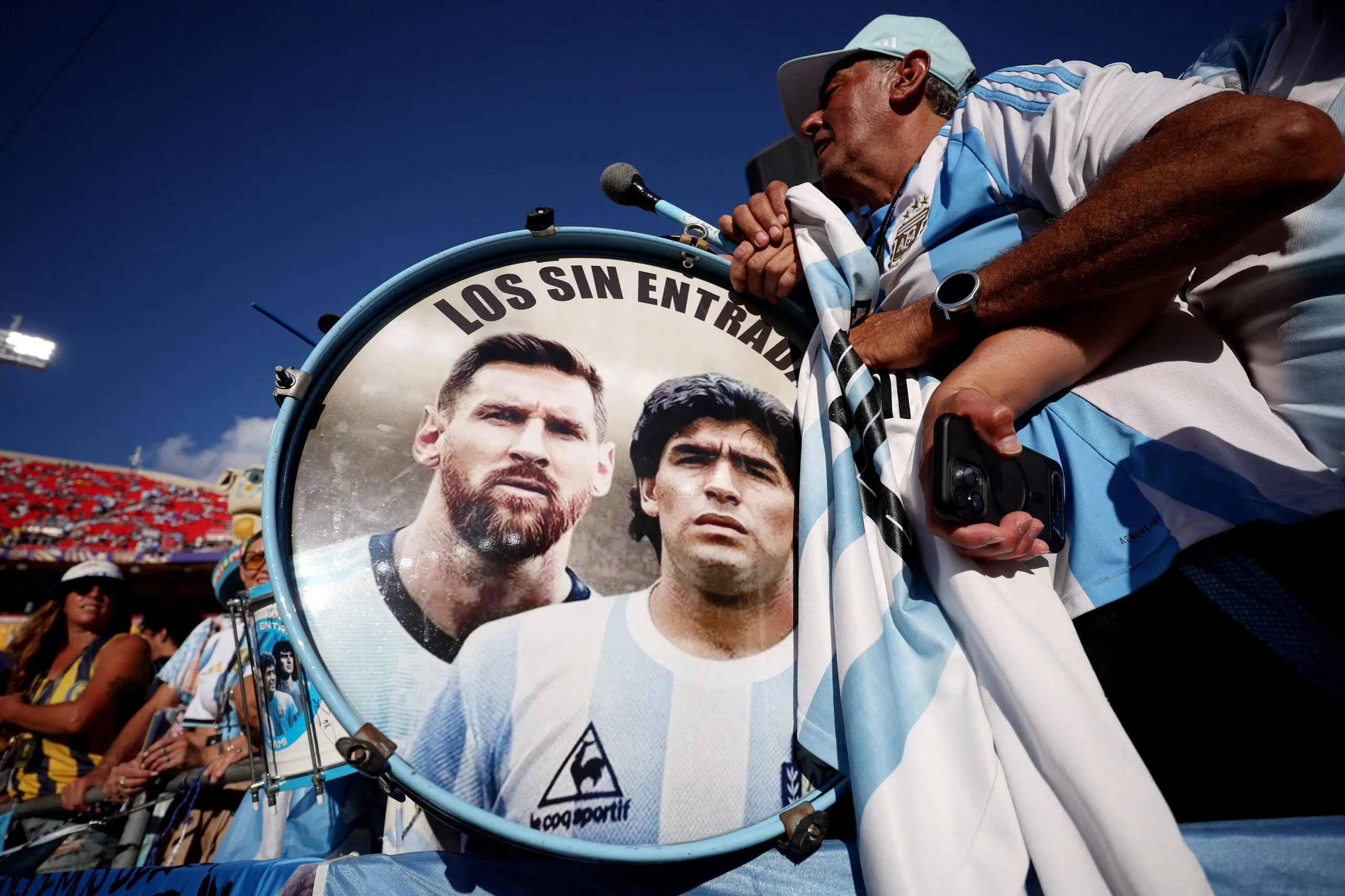 An Argentina fans holds a drum with the images of 